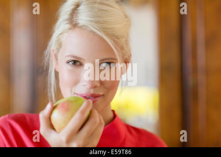 Frau zu essen Apfel im Innenbereich Stockfoto