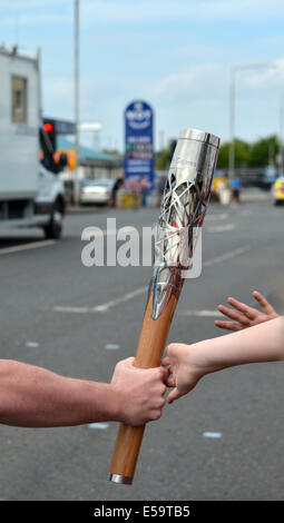 Die Queens Baton Relay, den Staffelstab von Kindern, die geduldig gewartet hatte, zu sehen, die Läufer berührt Stockfoto