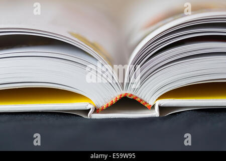 Ein offenes hardbacked Buch mit schwarzem Hintergrund. Stockfoto