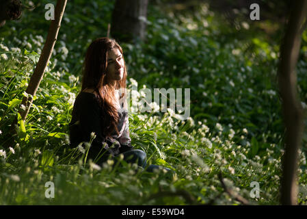 Frau sitzt im Wald. Stockfoto