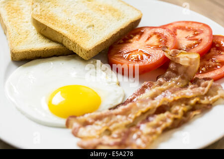 Leckeres englisches Frühstück mit Toast, Spiegelei, Speck und Tomaten hautnah Stockfoto