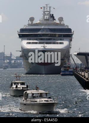 Rostock-Warnemünde, Deutschland. 22. Juli 2014. Der Luxusliner Norwegian Star ist in Rostock-Warnemünde, Deutschland, 22. Juli 2014 angedockt. Hinten gibt es in den benachbarten Seehäfen Celebrity Eclipse und Celebrity Constellation. Die drei Kreuzfahrtschiffe bringen mehr als 8.000 Passagiere nach Rostock und viele nehmen Sie den Zug für einen Tagesausflug nach Berlin. Die Ankunft der drei Schiffe im Hafen wird heute Abend von einem Port Teil mit live-Musik und Feuerwerk gefeiert. Foto: Bernd Wuestneck/ZB/Dpa/Alamy Live News Stockfoto