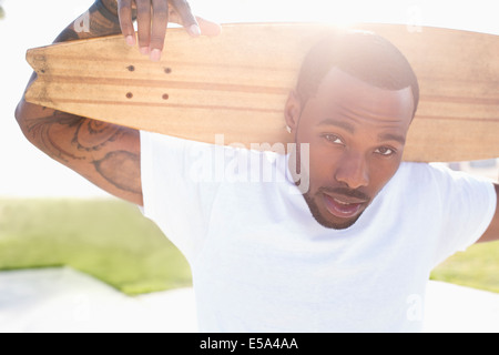 Afrikanische amerikanische Mann mit Skateboard im freien Stockfoto