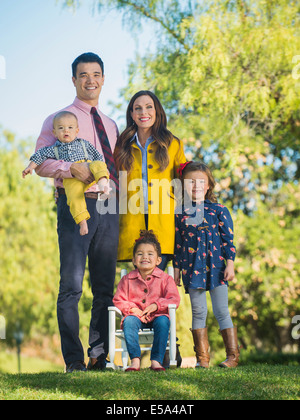 Familie lächelnd zusammen im freien Stockfoto