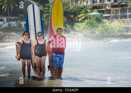 Spanische Freunde mit Surfbrettern am Strand Stockfoto