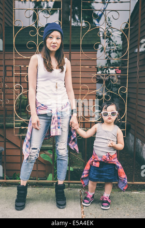 Koreanische Mutter und Tochter, die Hand in Hand auf Stadtstraße Stockfoto