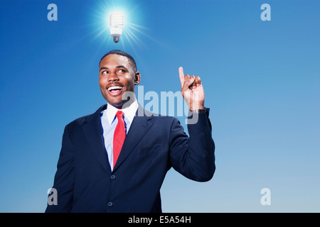 Gemischte Rassen Geschäftsmann mit Glühbirne über dem Kopf Stockfoto