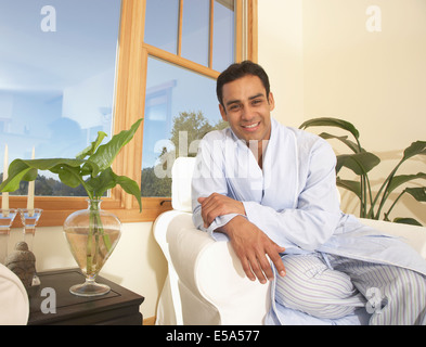 Hispanic Mann sitzt im Sessel Stockfoto