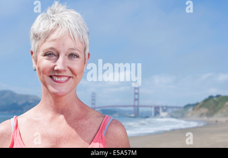 Senior kaukasischen Frau stand vor der Golden Gate Bridge, San Francisco, California, Vereinigte Staaten von Amerika Stockfoto