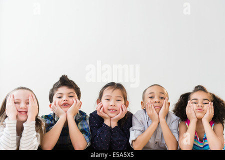 Kinder ruhen Kinn in Händen Stockfoto