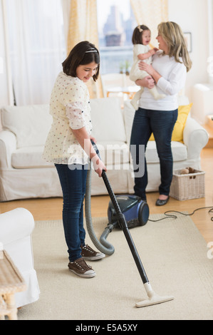 Hispanischen Mädchen saugen Wohnzimmer Stockfoto