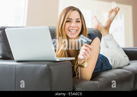 Gemischte Rassen Frau online-shopping auf sofa Stockfoto