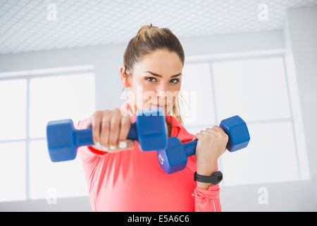 Gemischte Rassen Frau Heben von Gewichten im Fitnessstudio Stockfoto