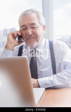 Hispano-Amerikaner Geschäftsmann reden über Handy am Schreibtisch Stockfoto