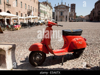 Eine alte rote Roller auf einem gepflasterten Platz in Mantova, Italien geparkt Stockfoto