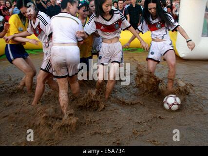 Zwei Gruppen von Mädchen in Deutschland Fußball team Trikot und Brasilien Nationalmannschaft Trikot Schlamm Fußball spielen am 13. Juli 2014 in Xi ' an, Shaanxi Provinz China.Mud Fußball aus Finnland entstanden ist, und es in China mehr und mehr populär geworden. Stockfoto