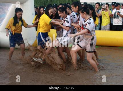 Zwei Gruppen von Mädchen in Deutschland Fußball team Trikot und Brasilien Nationalmannschaft Trikot Schlamm Fußball spielen am 13. Juli 2014 in Xi ' an, Shaanxi Provinz China.Mud Fußball aus Finnland entstanden ist, und es in China mehr und mehr populär geworden. Stockfoto