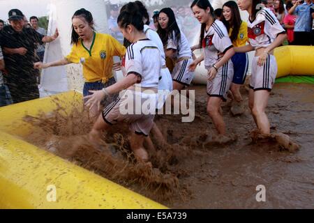 Zwei Gruppen von Mädchen in Deutschland Fußball team Trikot und Brasilien Nationalmannschaft Trikot Schlamm Fußball spielen am 13. Juli 2014 in Xi ' an, Shaanxi Provinz China.Mud Fußball aus Finnland entstanden ist, und es in China mehr und mehr populär geworden. Stockfoto