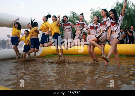 Zwei Gruppen von Mädchen in Deutschland Fußball team Trikot und Brasilien Nationalmannschaft Trikot Schlamm Fußball spielen am 13. Juli 2014 in Xi ' an, Shaanxi Provinz China.Mud Fußball aus Finnland entstanden ist, und es in China mehr und mehr populär geworden. Stockfoto