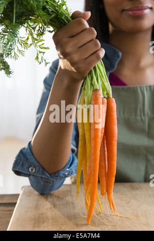 Gemischte Rassen Frau mit Haufen von Karotten Stockfoto