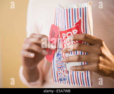 Gemischte Rassen Frau mit Tasche von Popcorn und Film-tickets Stockfoto