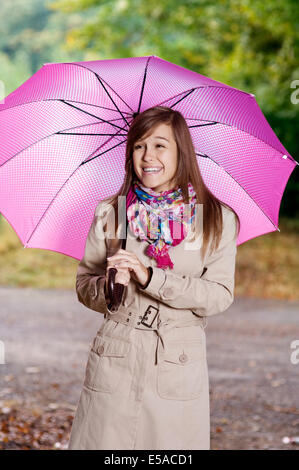 Junge Frau mit Regenschirm zu Fuß durch den Park, Debica, Polen. Stockfoto