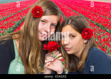 Zwei Mädchen mit roten Rosen vor Tulpenfeld Stockfoto