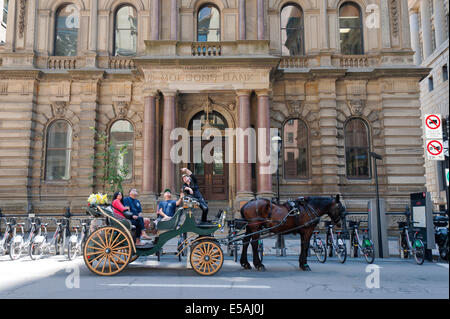 Eine Pferdekutsche Kutschenfahrt in Old Montreal. Der Fahrer ist die umliegenden Gebäude an seine Kunden beschreiben. Stockfoto