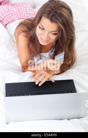Junge Frau mit Laptop im Bett, Debica, Polen Stockfoto