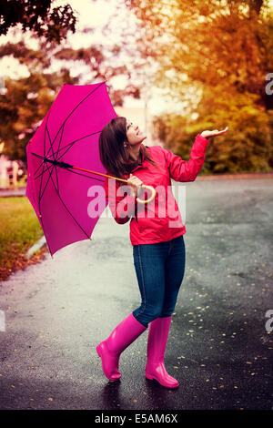 Glückliche Frau mit Regenschirm Regen in einem Park Debica, Polen gesucht Stockfoto