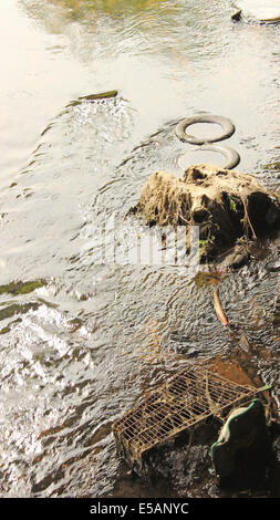 Urban Wasser Weg durch illegale Verbringung Müll wie Reifen und einem alten Einkaufswagen verursachten Umweltschäden. Stockfoto