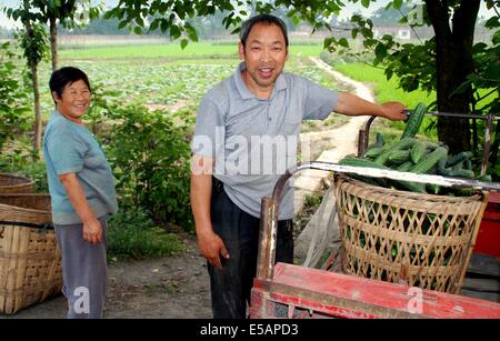 PENGZHOU, CHINA: BAUERN LADEN EINEN KORB MIT GURKEN AUS IHREN FELDERN BRINGT SIE ZU DEN LOKALEN MÄRKTEN ZU VERKAUFEN Stockfoto