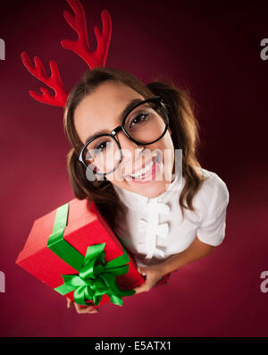 Nerdy Frau mit Hörnern und Weihnachtsgeschenk Debica, Polen Stockfoto