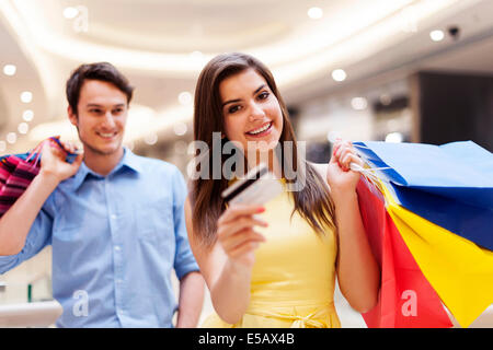 Glückliche Frau hält Kreditkarte und shopping Taschen Debica, Polen Stockfoto