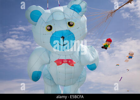 Lytham St Annes, Blackpool, 26. Juli 2014. St. Annes kite Festival. Teddybär aufblasbare Drachen in den Himmel über St Annes Strandpromenade, überschwemmt mit Farbe als fabelhafte Anzeige Drachen in der Luft auf den Strand in der Nähe der Pier. Der Himmel über St Annes Strandpromenade waren überschwemmt mit Farbe als fabelhafte Anzeige Drachen in der Luft auf den Strand in der Nähe der Pier, und mit einem riesigen blauen Aufblasbare Teddybär. Stockfoto