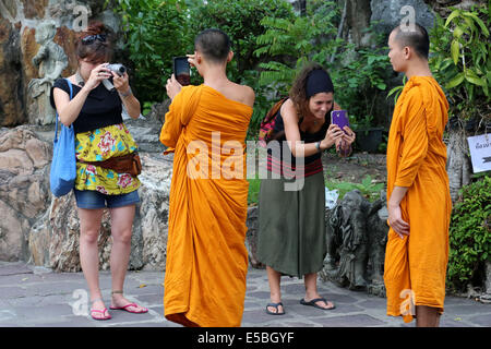 Touristen im Wat Pho Tempel Fotografieren von buddhistischen Mönchen als sie die Touristen fotografieren. Tempel Wat Pho, Bangkok Stockfoto