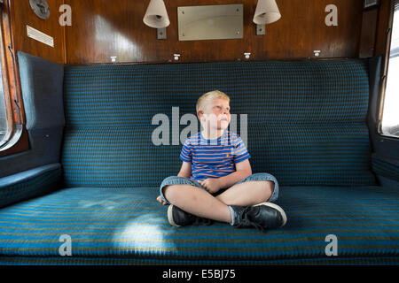 Junge in alten Eisenbahnwagon Tagträumen Stockfoto