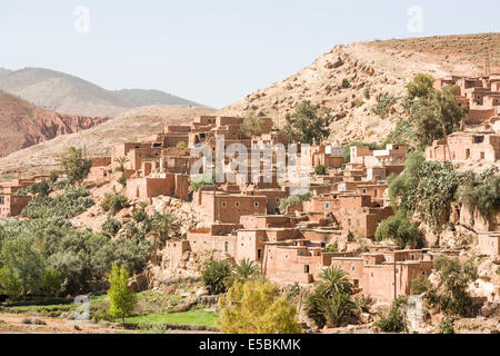 Rote Backsteinhäuser, einige Ruinen, ein Berber-Dorf, gebaut auf einem Hügel im Atlasgebirge, Marokko Stockfoto