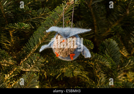Eine gestrickter Eule Ornament hängt in einem sanft beleuchteten Weihnachtsbaum Stockfoto