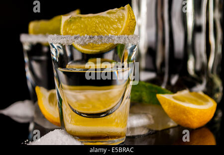 Tequila mit Zitrone oder Limette und Salz auf reflex Hintergrund Stockfoto