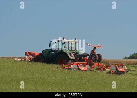 Traktor zieht Grass-Cutter schneiden Rasen für die Herstellung von Heu Stockfoto