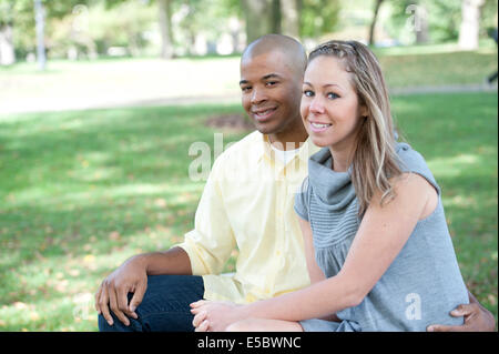 Glückliche junge interracial Paar posieren zusammen an einem sonnigen Tag. Stockfoto