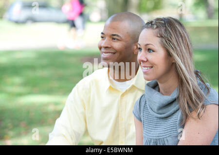 Glückliche junge interracial Paar posieren zusammen an einem sonnigen Tag. Stockfoto