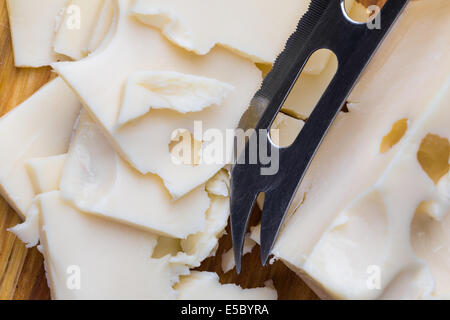 weißer Käse Maasdam mit Messer auf Holz geschnitten Stockfoto