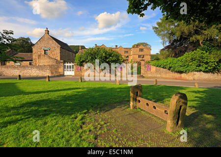 Eyam Hall und Aktien auf dem Dorfanger Eyam Pest Dorf, Derbyshire, Peak District National Park, England, UK. Stockfoto