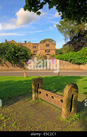 Eyam Hall und Aktien auf dem Dorfanger Eyam Pest Dorf, Derbyshire, Peak District National Park, England, UK. Stockfoto