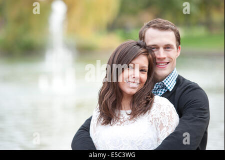 Ein attraktives junges Paar posieren am Teich an einem sonnigen Tag. Stockfoto