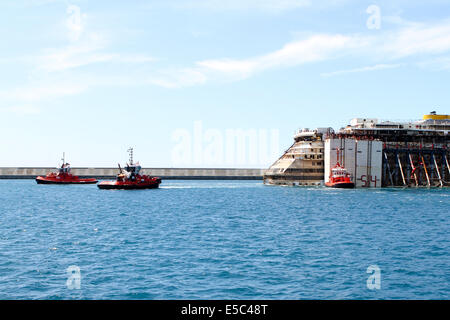 Genua, Italien. 27. Juli 2014. Concordia Wrack kommt am Hafen von Genua Prà-Voltri mit mehreren Schleppern gezogen. Concordia sank in Isola del Giglio im Januar 2012. Stockfoto