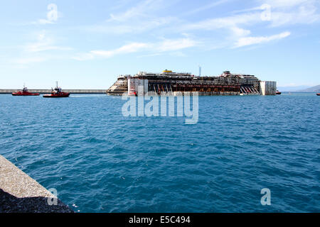 Genua, Italien. 27. Juli 2014. Costa Concordia Kreuzfahrt Schiffswrack kommt am Hafen von Genua Prà-Voltri mit mehreren Schleppern gezogen. Stockfoto