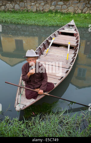 Vietnamesische Mann mit langem Bart im Ruderboot in HoiAn Kanal Stockfoto